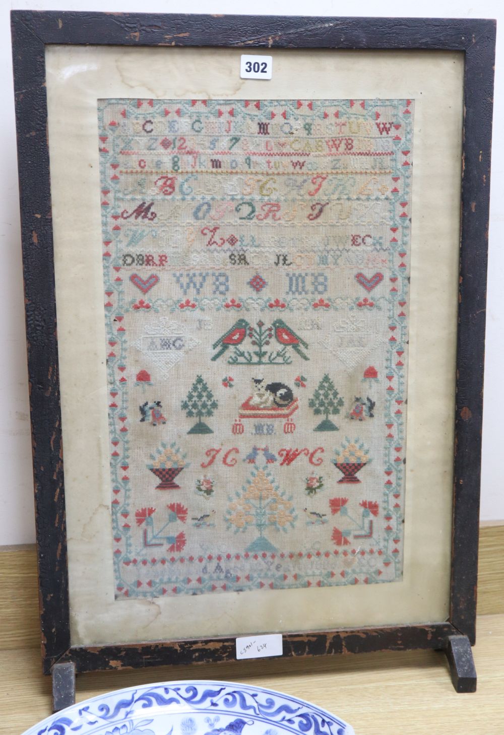 A needlework sampler dated 1886, framed as a firescreen, overall height 71cm